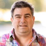 Headshot of Brian Fink, guest host for Agile&rsquo;s Last Friday Job Party webinar, smiling in a professional portrait setting.