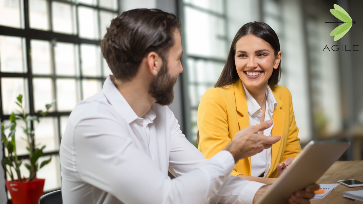 Hiring manager and recruiter reviewing a job description on a laptop during a meeting